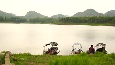 坐在湖边的人和渔船视频的预览图